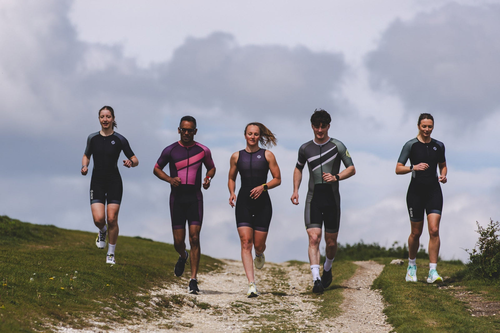 Female triathlete running in a purple SLS3 tri suit during training, representing the determination, resilience, and commitment that define the sport.