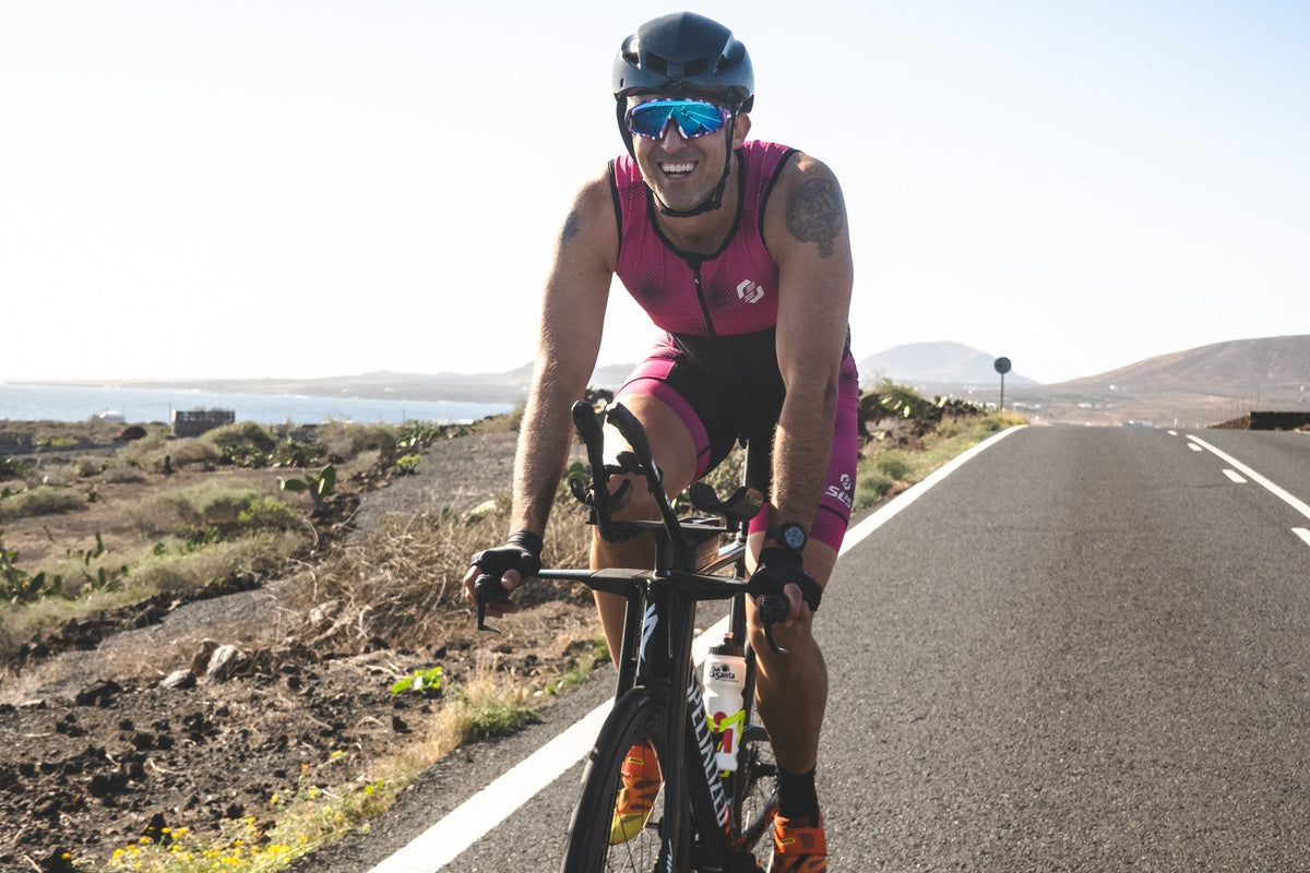 Triathlete completing a road cycling session in hot weather as part of triathlon heat training.