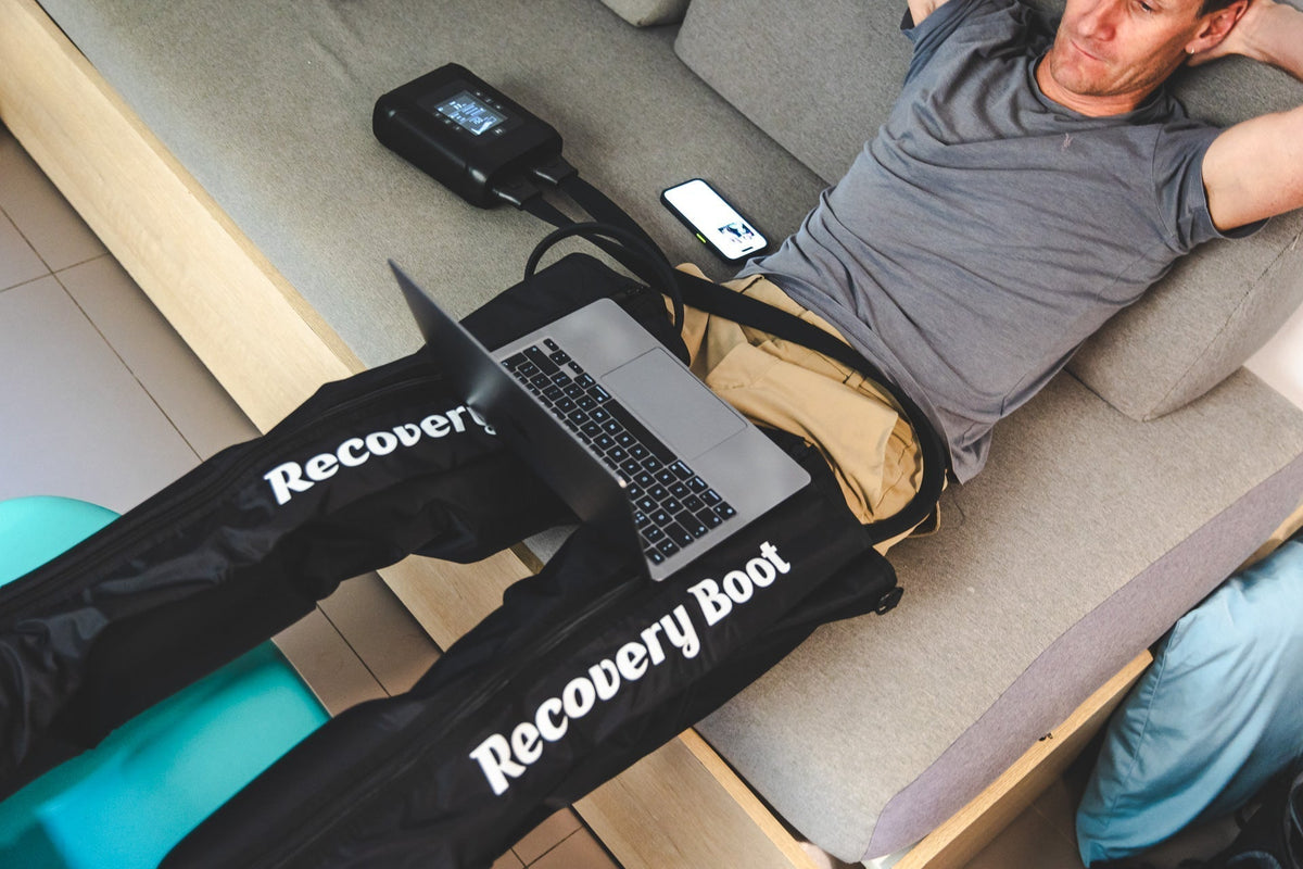 Athlete using compression boots at home after training to support leg recovery and reduce post-exercise muscle soreness.